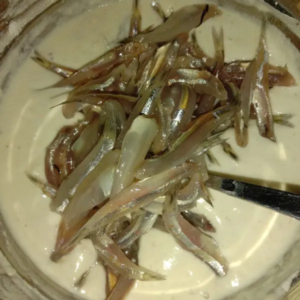 Masukkan ikan teri, aduk sampai ikan teri terbaluri dengan tepung.