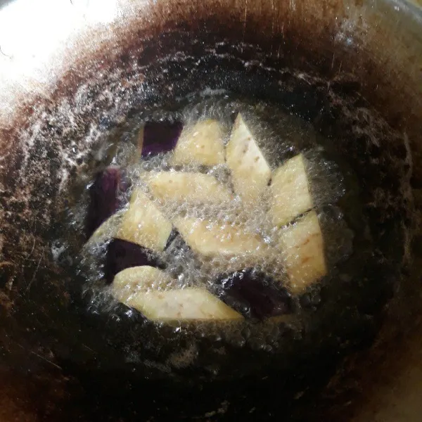 Potong dan cuci terong, lalu goreng dan tiriskan.