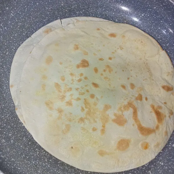 Olesi tortilla dengan margarin secukupnya kemudian panggang hingga sedikit kecokelatan.