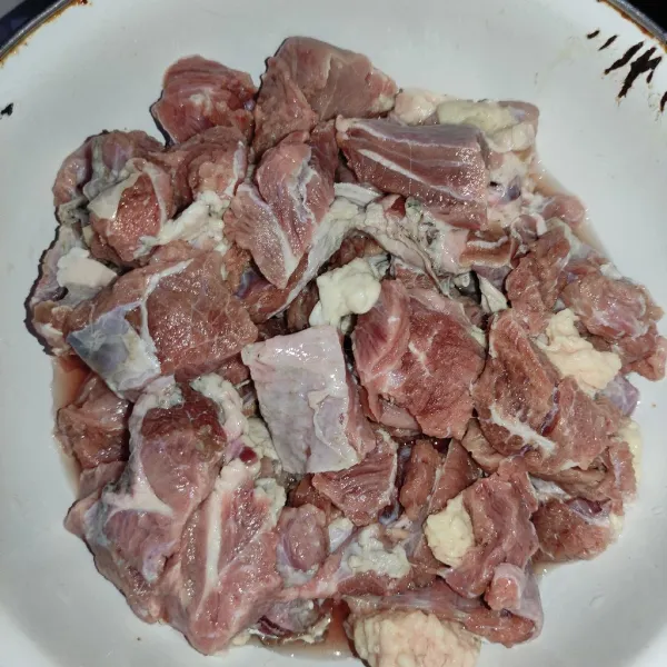 Potong-potong daging sapi lalu beri perasan jeruk nipis dan garam, baluri daging hingga bahan meresap.