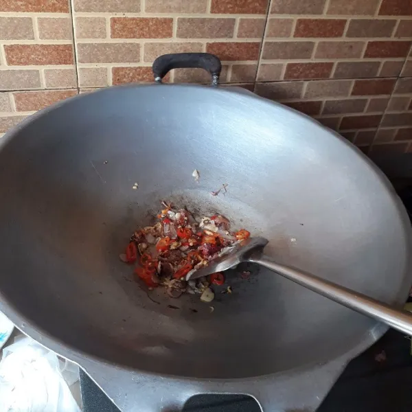 Tumis bawang putih dan bawang merah hingga matang dan harum. Masukkan cabai, masak hingga cabai layu.