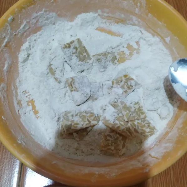 Baluri potongan tempe dengan tepung terigu.