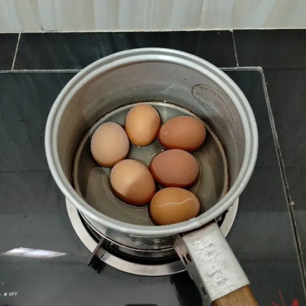 Rebus telur dengan air secukupnya hingga matang, lalu kupas.