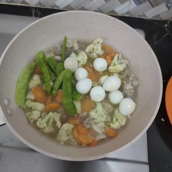 Setelah mendidih, masukkan kapri dan telur puyuh lalu bumbui dengan gula pasir, garam dan kaldu bubuk.