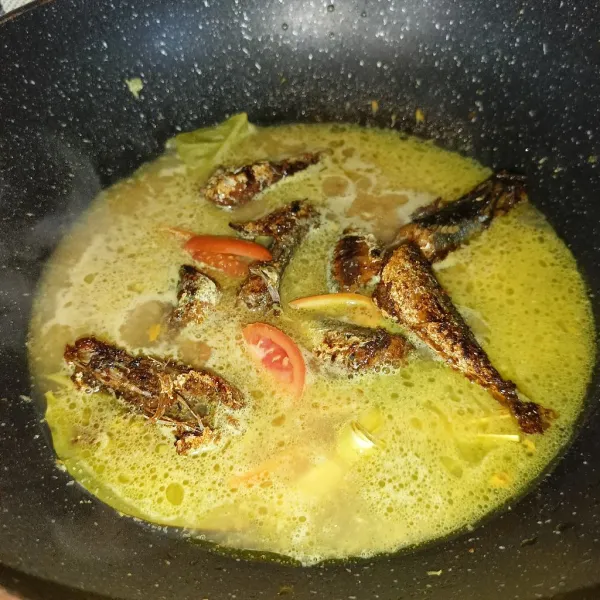 Masukkan air dan setelah mendidih masukkan ikan lajang goreng dan tomat merah, masak sampai ikan meresap.
