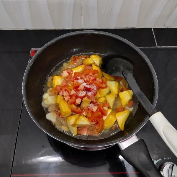 Kemudian masukkan tahu kuning, tomat merah, garam dan gula pasir. Aduk rata dan masak hingga mendidih kembali.