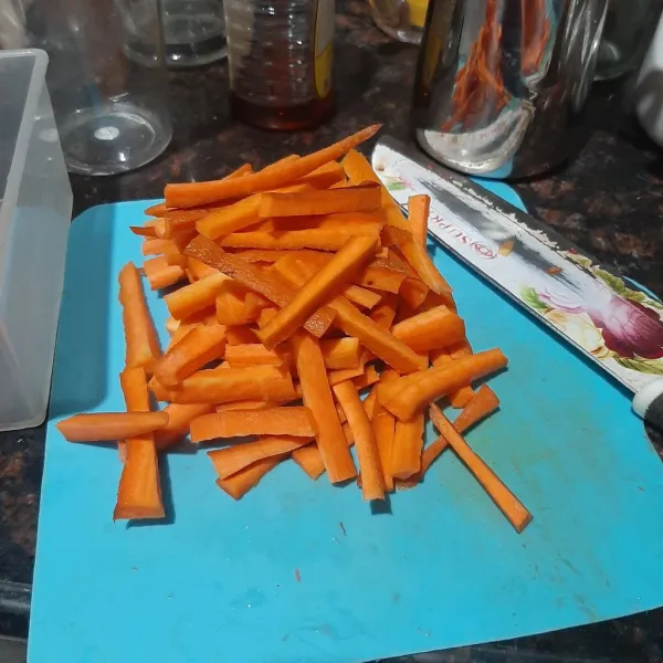 Cuci bersih wortel, lalu potong korek.