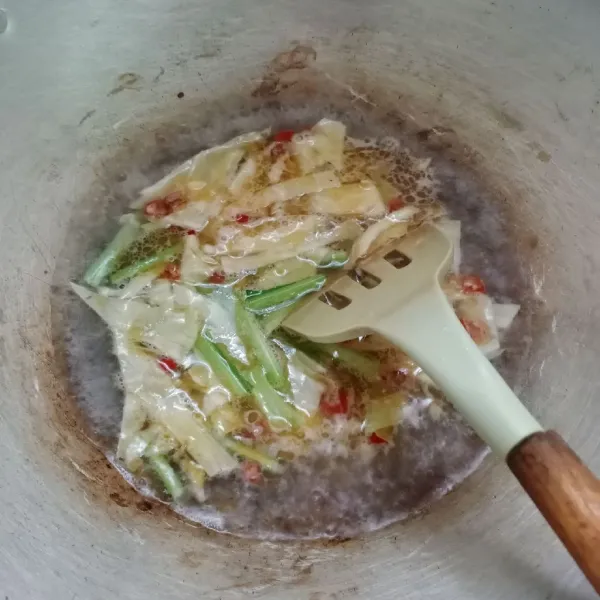 Tuang air, masukkan kubis dan batang sawi. masak hingga setengah matang.