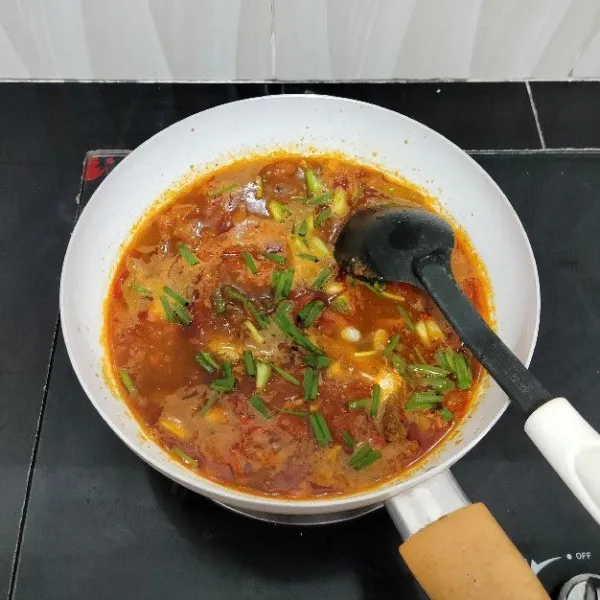 Masak hingga bumbu meresap, lalu taburi daun bawang, angkat.