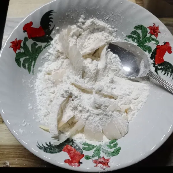 Balutkan jamur tiram pada campuran tepung sambil ditekan-tekan agar tepung menempel.