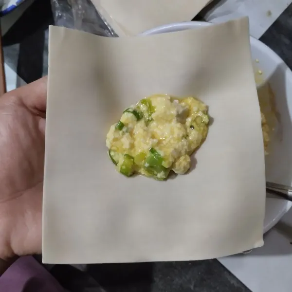 Ambil selembar kulit pangsit. Beri setengah sendok makan adonan tahu, lipat menyerupai amplop.