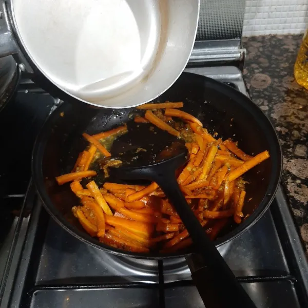 Masukkan wortel, aduk-aduk hingga tercampur bumbu lalu tuang air. Tunggu hingga mengental.