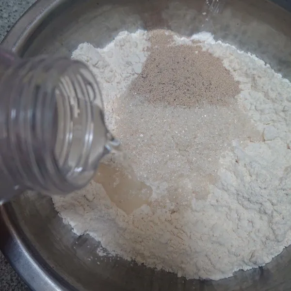 Dalam wadah, campur tepung terigu, tepung maizena, gula pasir, ragi instan. Tambahkan air, aduk rata.