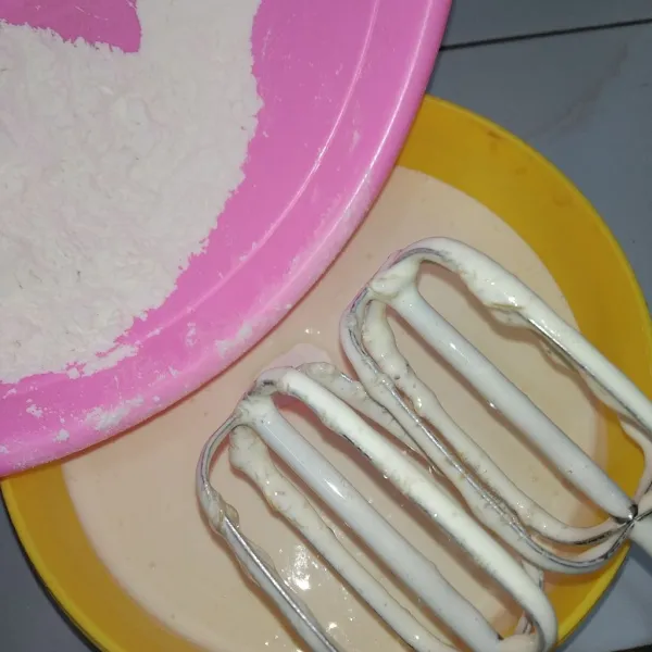 Masukkan setengah bagian campuran dari tepung terigu, soda kue, dan vanilli bubuk, mixer asal rata