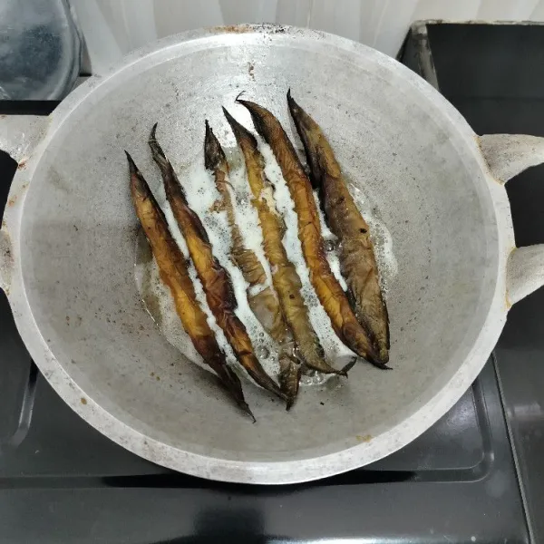Cuci bersih ikan sili asap, lalu goreng sebentar dalam minyak panas, tiriskan.