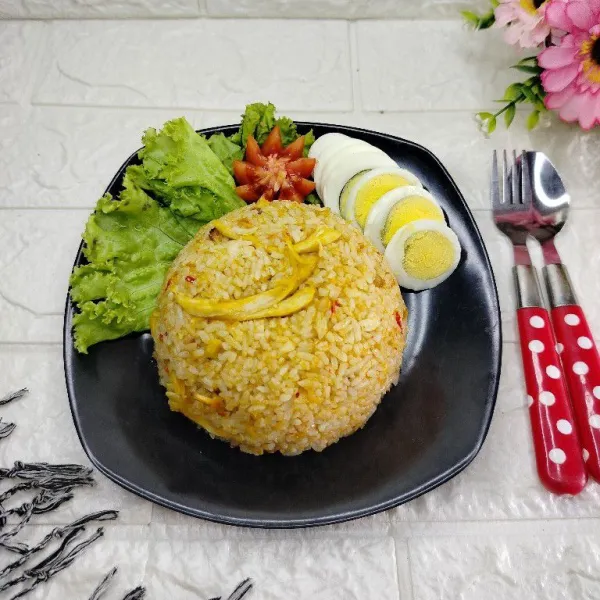 Tuang nasi goreng ke dalam piring. Sajikan dengan pelengkapnya.