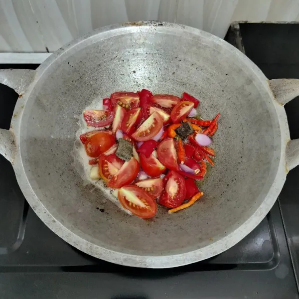 Goreng cabai merah, cabai rawit, bawang merah, bawang putih, tomat merah dan terasi dengan minyak secukupnya hingga layu, angkat.