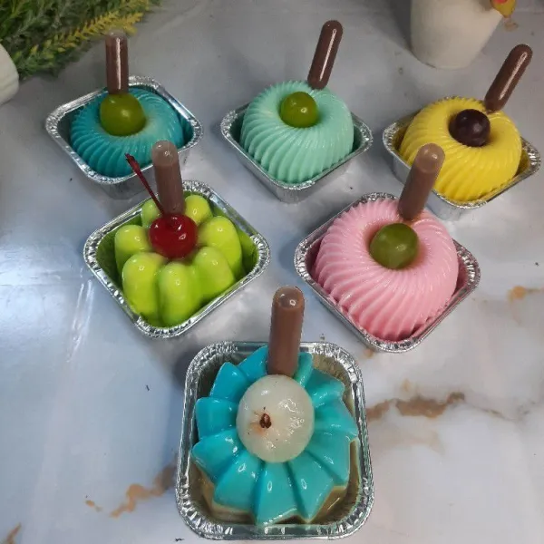 Buka puding dari cetakan lalu beri topping buah dan vla.