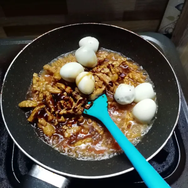 Masukkan tempe dan telur puyuh. Bumbui dengan garam, gula pasir, kaldu bubuk dan kecap manis.