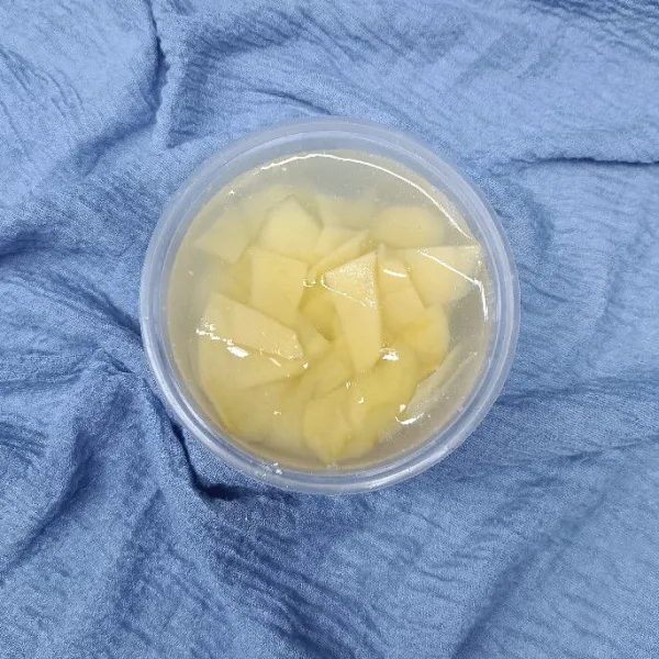 Masukkan irisan tipis kentang. Diamkan selama 10 menit. Setelah itu tiriskan kentang dari air rendaman.