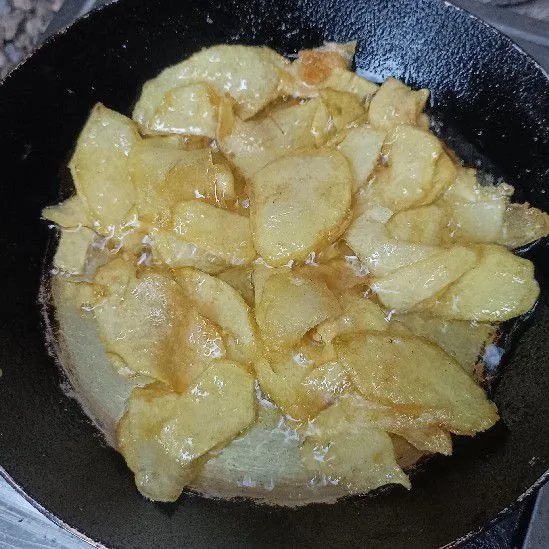 Goreng kentang ke dalam minyak panas sambil terus dibolak-balik hingga hasilnya garing.