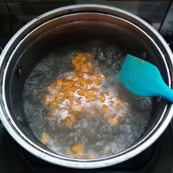Tuang tumisan bumbu ke dalam rebusan wortel.