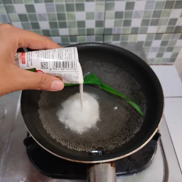 Masukkan air, garam, vanili serta daun pandan ke dalam wajan. Jika sudah mendidih masukkan santan.
