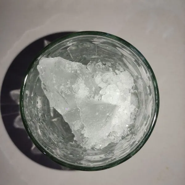 Masukkan ice cube ke dalam gelas yang sudah disiapkan.