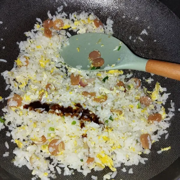 Tambahkan nasi putih, saos tiram, aduk hingga tercampur rata, koreksi rasa. Setelah matang merata, angkat dan sajikan.
