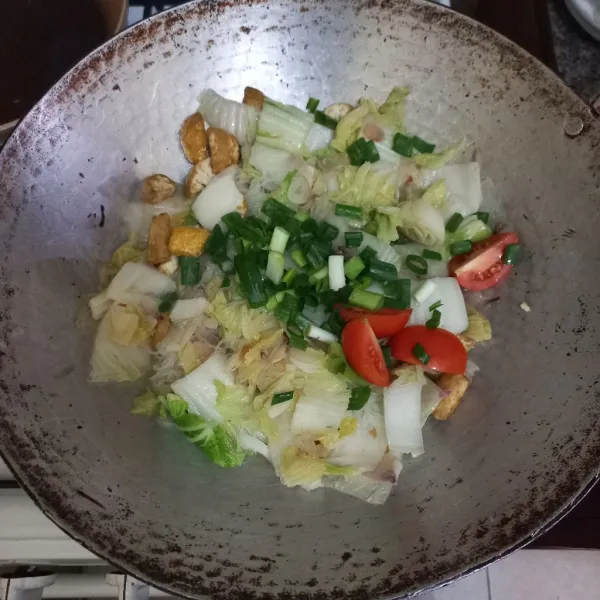 Masukkan irisan daun bawang dan tomat merah, masak hingga layu. Angkat dan sajikan.