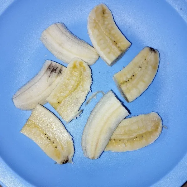 Belah pisang menjadi 2 bagian kemudian potong kembali menjadi 4 bagian.