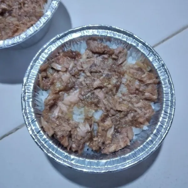 Tata nasi putih di dasar cup aluminium foil, tambahkan tumisan ikan tuna di atas nasi.