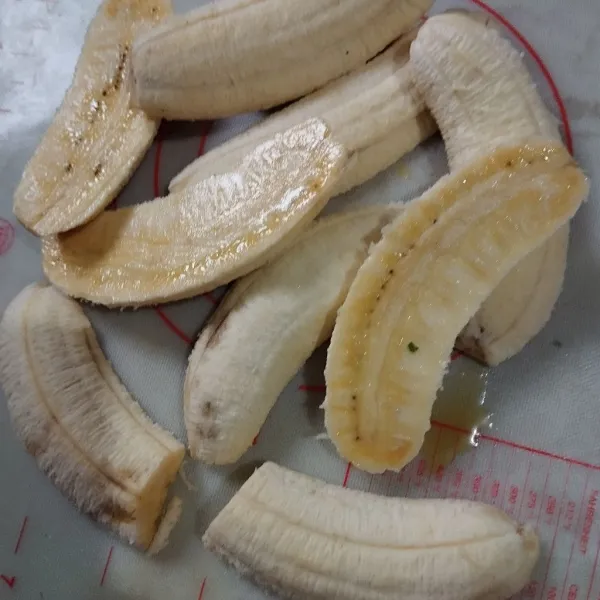 Belah dua pisang menjadi dua bagian.
