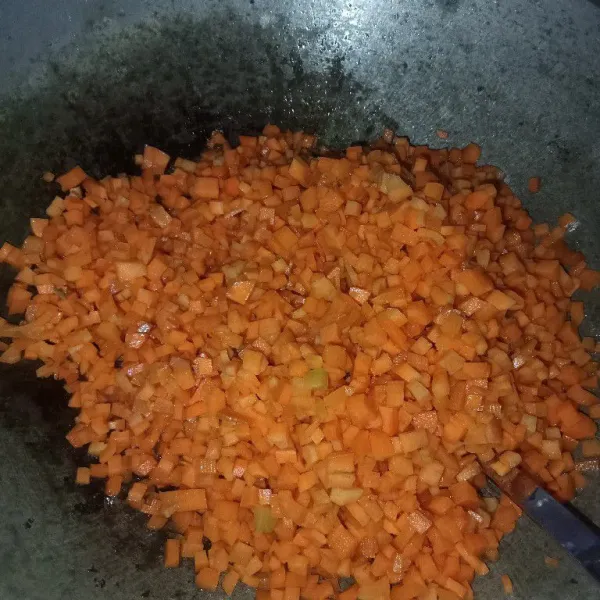 Masukkan wortel aduk rata dengan bumbu, kemudian tuang air. Masak wortel hingga mulai matang.