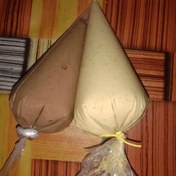 Bagi adonan jadi 2 bagian, 1 bagian beri cokelat bubuk, aduk rata. 1 bagian lainnya beri kopi tiramisu, aduk rata. 
Lalu masukkan masing-masing adonan ke dalam plastik segitiga.