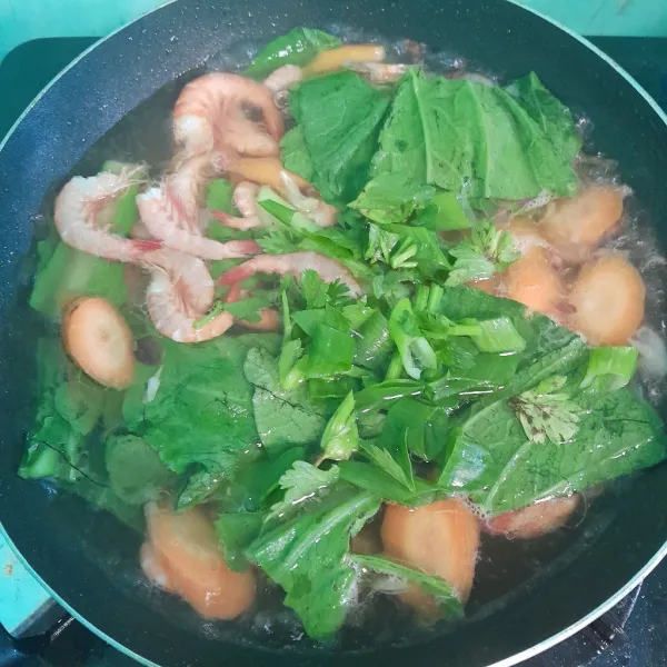 Tambahkan daun seledri dan daun bawang, masak sampai matang.