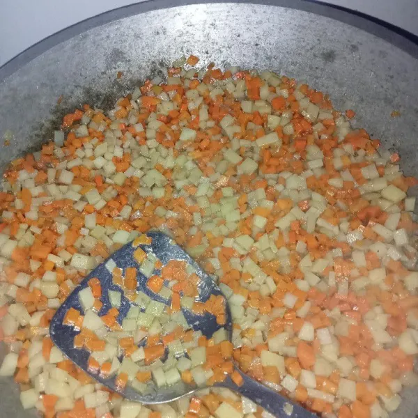 Aduk rata kentang, wortel dan bumbu hingga sayuran matang.