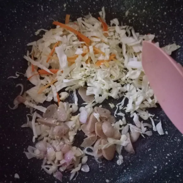 Masukkan bakso yang sudah diiris, kol, dan wortel. Tumis hingga sayuran layu.