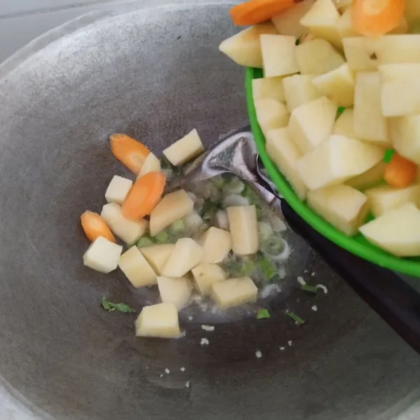 Masukkan kentang dan wortel, aduk agar tidak lengket.