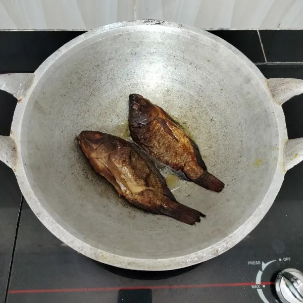 Goreng sebentar ikan mujair asap dalam minyak panas, tiriskan.