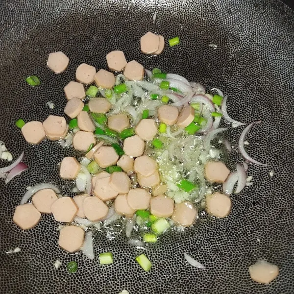 Tambahkan sosis dan daun bawang.
