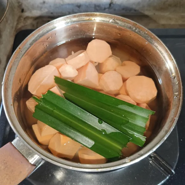 Rebus ubi, daun pandan dan air di dalam panci.