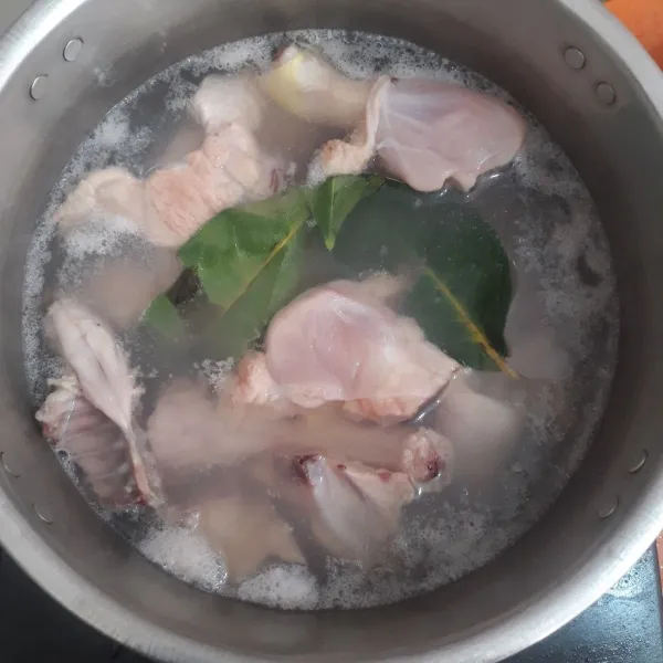 Cuci bersih ayam, lalu rebus bersama daun salam untuk mengurangi bau amis.