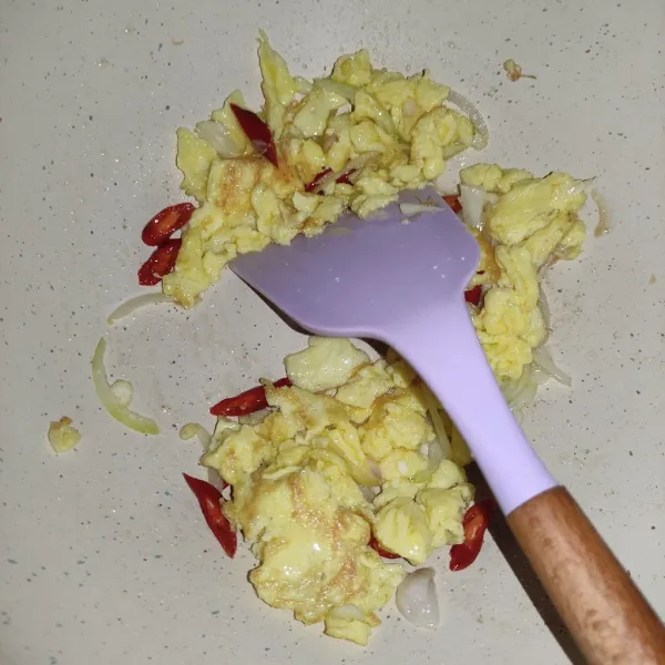Sisihkan telur, lalu tumis bawang merah, bawang putih, dan bawang bombay, masukkan irisan cabe.
