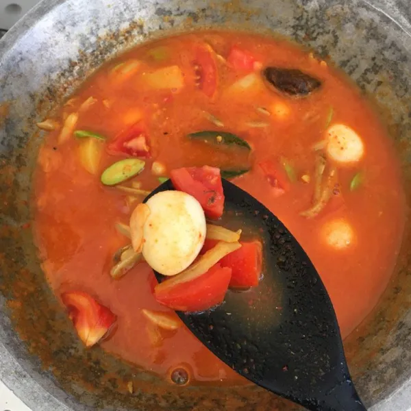 Tambahkan telur puyuh rebus dan potongan tomat merah. Masak kembali selama 7-8 menit sambil sesekali diaduk. Periksa tingkat kematangan kentang, jika sudah sesuai, matikan api.