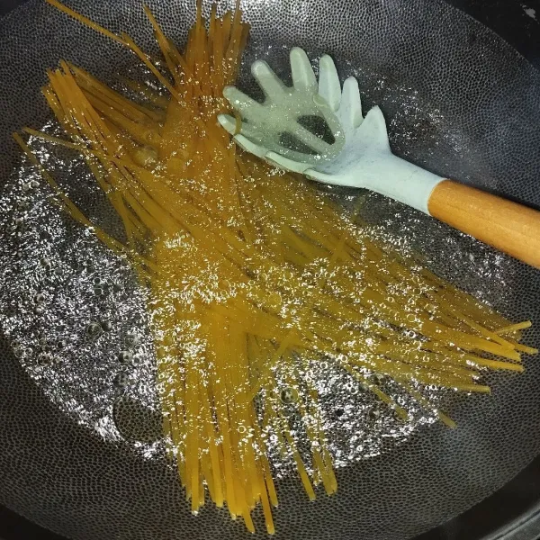 Rebus spaghetti dengan air dan minyak hingga al dente
