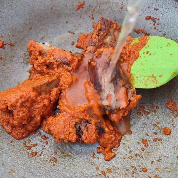 Masukkan ikan tongkol goreng, aduk rata dengan bumbu lalu tambahkan air dan masak sampai mendidih.