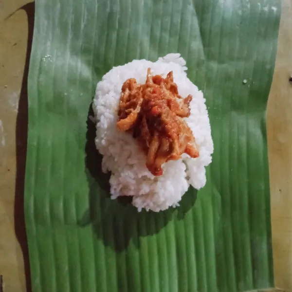 Beri isian ayam 1 sendok makan sambal di atasnya kemudian bungkus. Lipat ke dua ujung daun dan sematkan dengan tusuk gigi. Siap dihidangkan dan dapat disajikan dengan telur rebus.