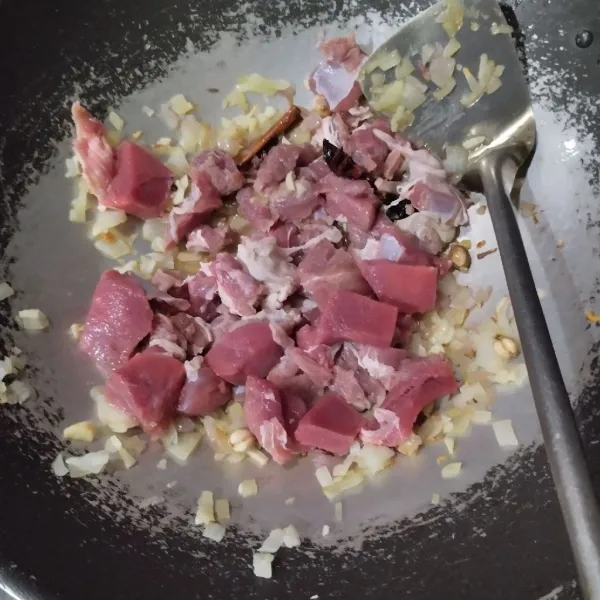 Masukkan daging, aduk hingga berubah warna lalu masukkan bubuk kari, aduk rata.
