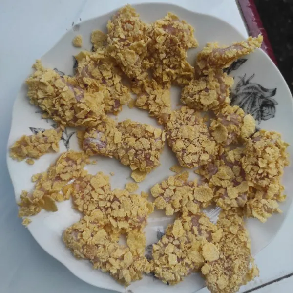 Baluri ayam dengan corn flakes yang sudah dihancurkan.